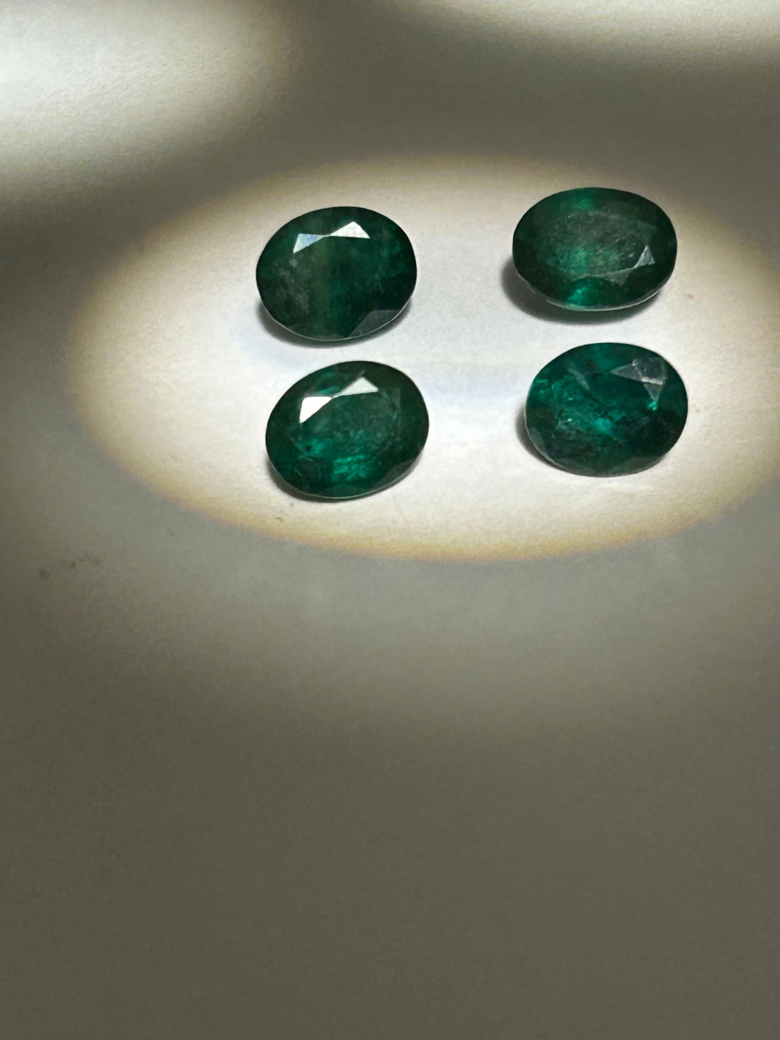 4 NATURAL DARK GREEN ZAMBIAN EMERALDS OVAL CUT 3.5 tcw: Deep, rich green color with slight bluish undertones and high clarity. Sourced from Zambia, these stones are renowned for superior luster