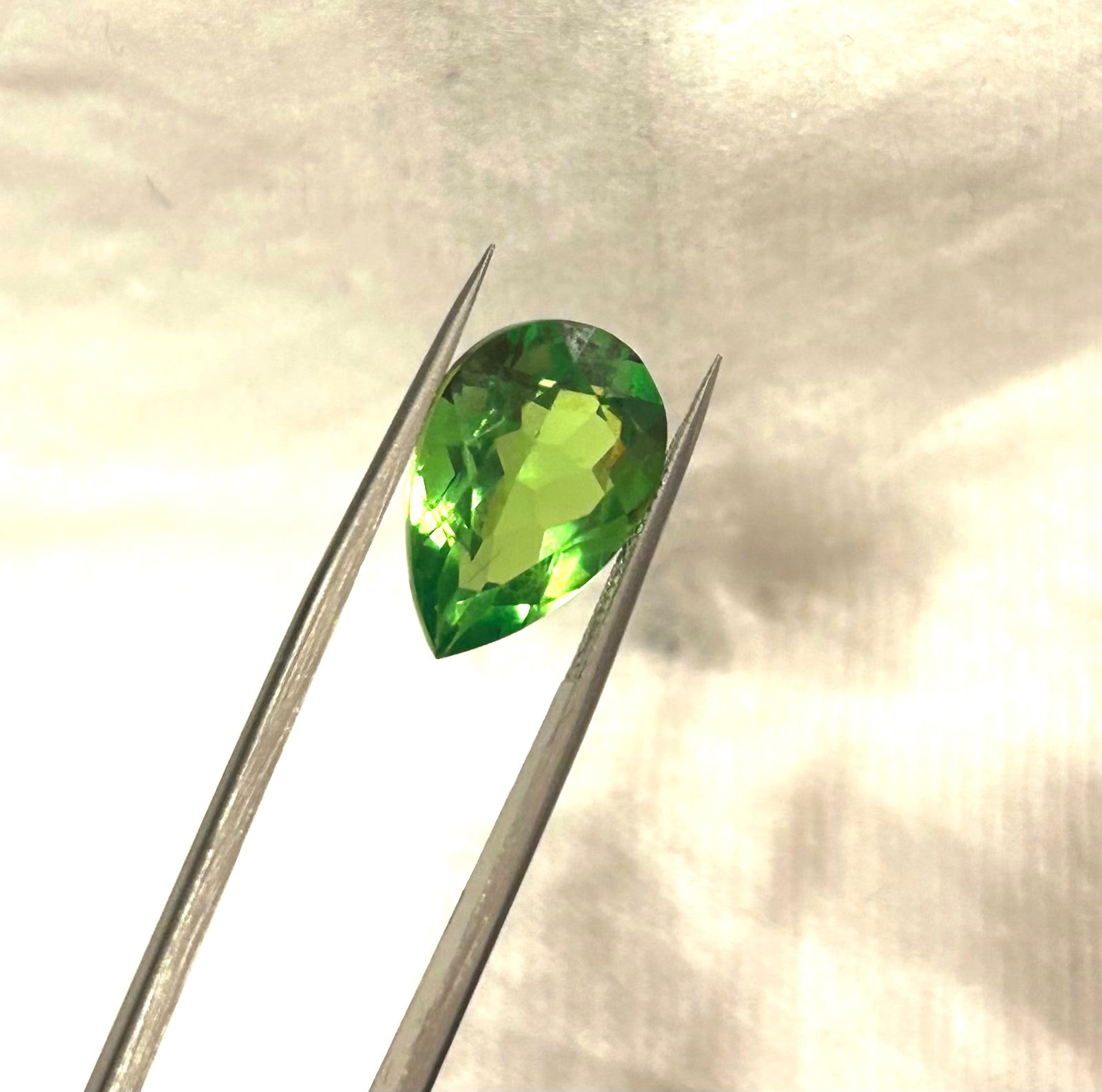 Natural Green Peridot 10 Ct Pear cut: high-quality gemstone, featuring a vibrant, lime green color with excellent, eye-clean clarity. Sourced from Afghanistan, this large, pear-shaped gem displays superior brilliance.
