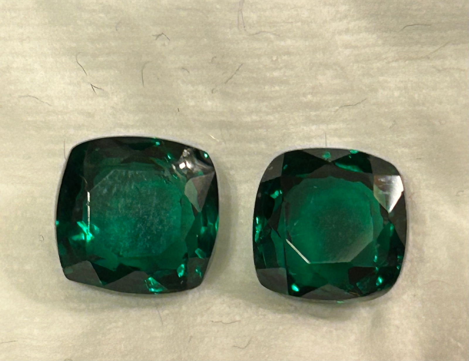 Deep Green Emerald Cushion Cut Transparent 20 ct from Columbia PAIR: Two large, natural Colombian emeralds, weighing roughly 10 carats each, featuring a cushion cut for timeless sparkle. A desirable deep green color with good clarity, ideal for statement jewelry.