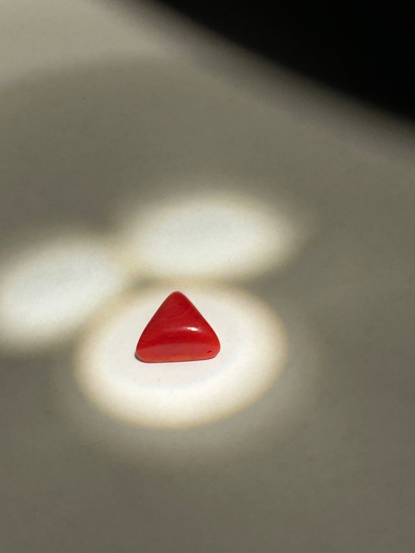 Natural Carnelian Agate 6.42ct Triangle Cabochon Cut from Brazil IGI Certification No Reserve: Brazilian chalcedony is a translucent to opaque gemstone featuring a triangular cabochon cut. Typically sourced from Brazil, this material displays soft orange tones, polished into a smooth, domed sha