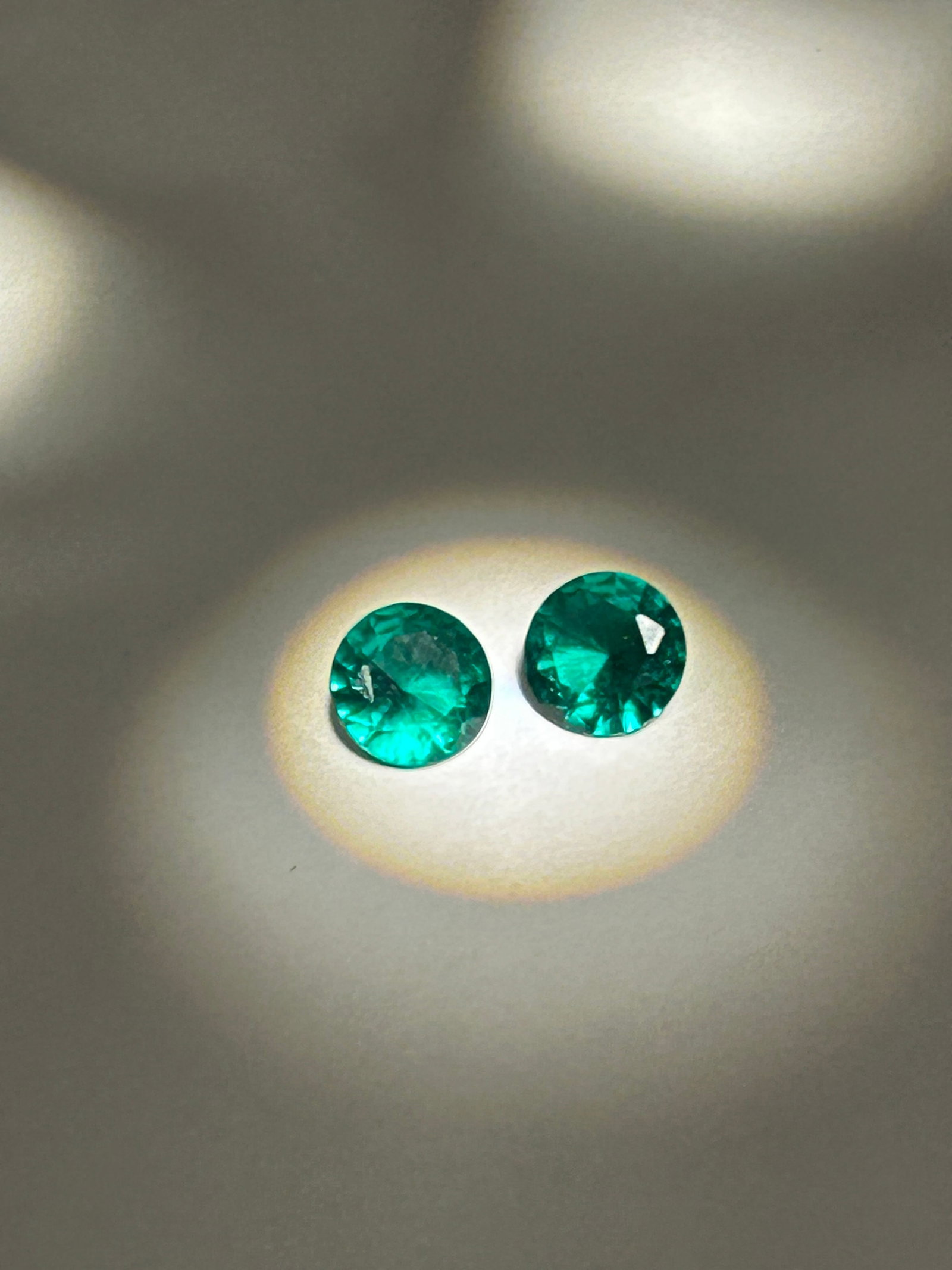 2.2ct Colombian Green Emerald PAIR Round Cut: a rare and brilliant round cut, offering exceptional vivid green color and high luster. Mined in Colombia, these stones typically display a lush, vibrant green with minor, natural inclusions.