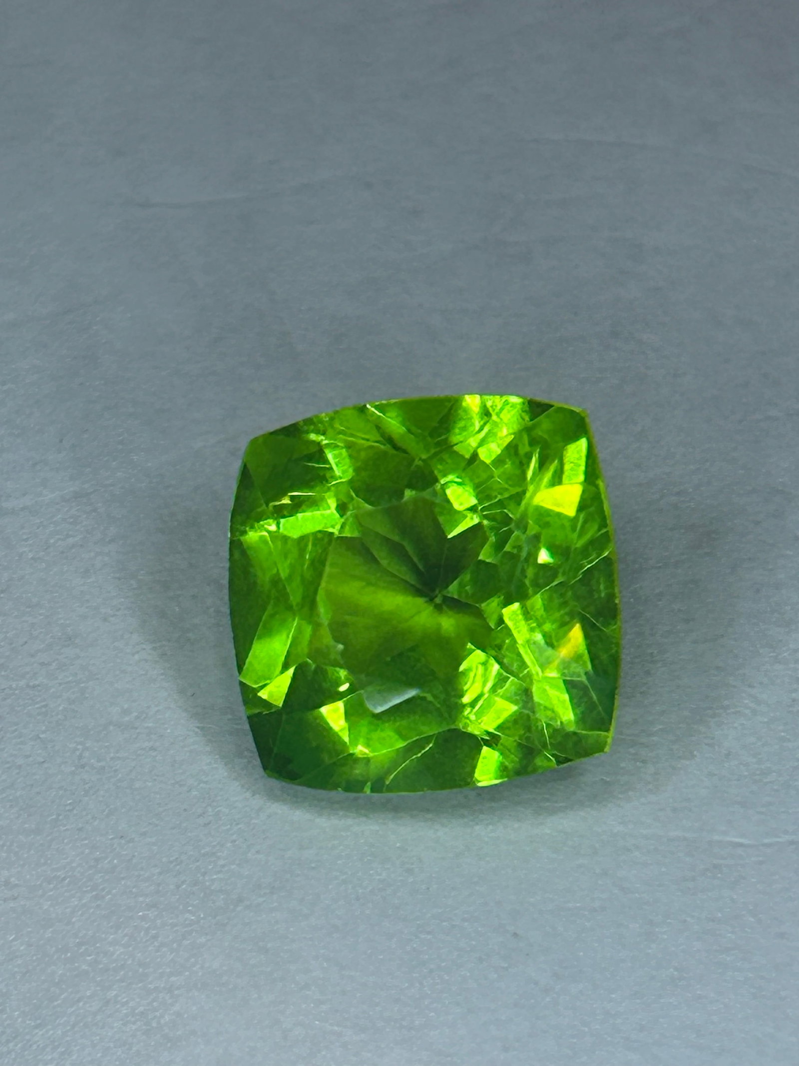 9.70 Carat Peridot Cushion Cut GGL Certified: a substantial, impressive gemstone often characterized by a vibrant olive or apple-green color, with high-quality specimens sourcing from Pakistan or Africa. At nearly 10 carats, this stone is large e