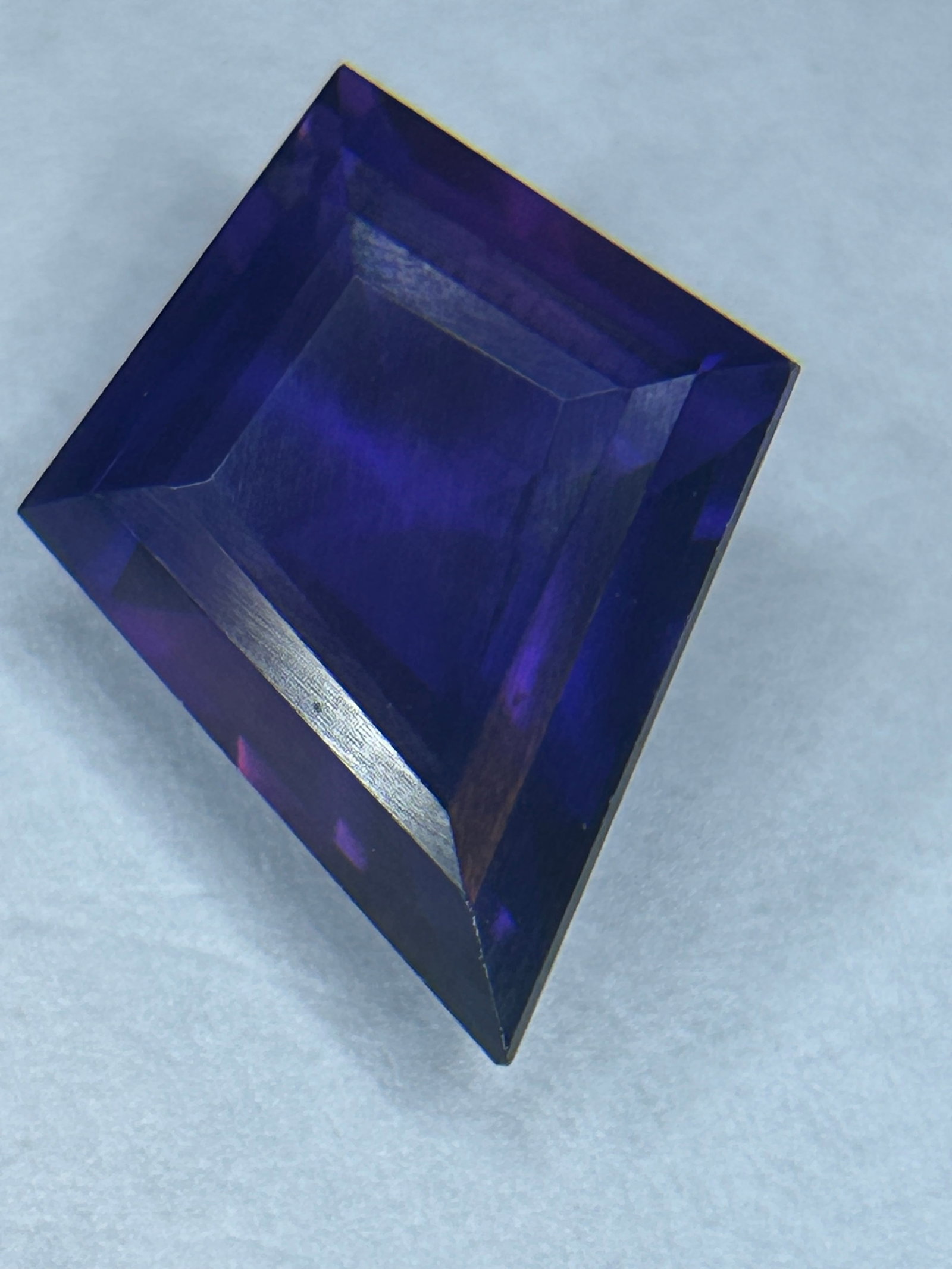 10.38 Carat Deep Purple Amethyst Kite Cut EGL Certified: It features a bold, triangular-based geometric shape with a large table to maximize light reflection, often exhibiting vibrant, rich violet hues, suitable for custom rings or pendants.