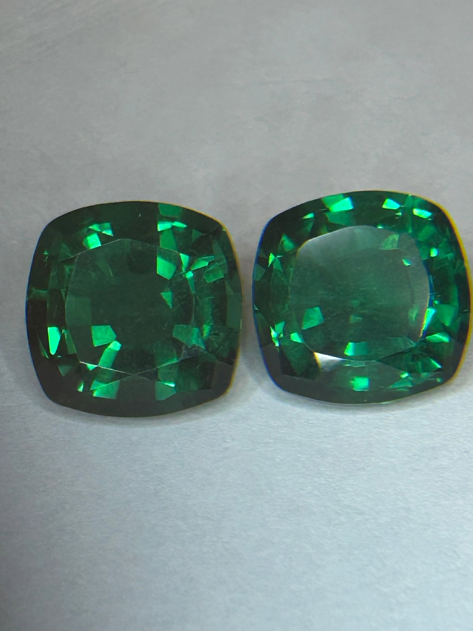 20.00 Carat PAIR Columbian High Crystal Emerald Cushion Cut EGL Certified: "High Crystal" means the stones have high transparency with minimal, soft inclusions, allowing light to travel through the stone rather than being absorbed by a "jardin". Investment-grade Colombian em