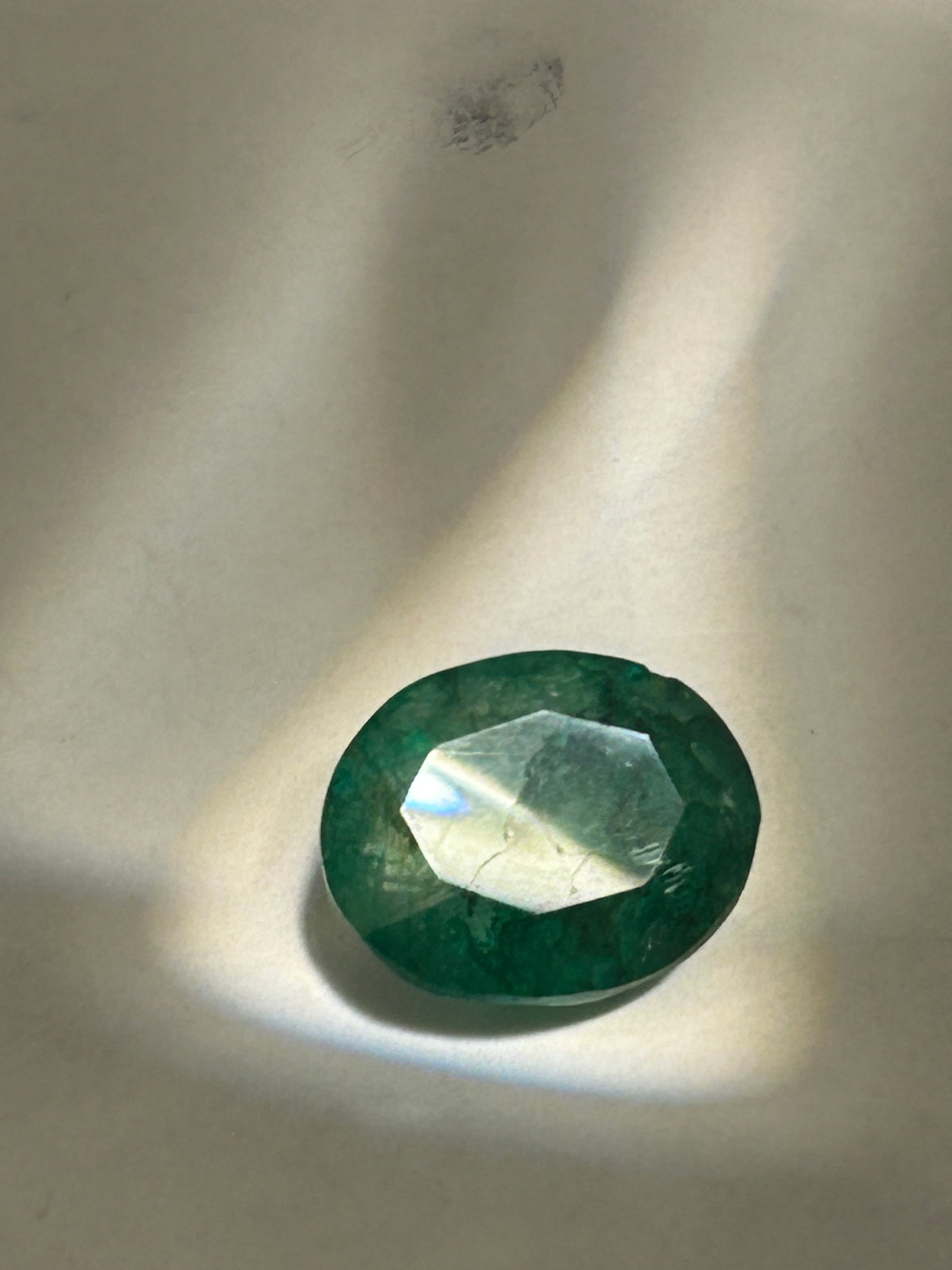 13.70 Carat Colombian Green Emerald Oval Cut VG Certified: A high-carat gemstone characterized by a rich green hue, featuring eye-clean to included clarity typical of natural beryl. These stones, found in faceted or polished forms, are popular for statement j