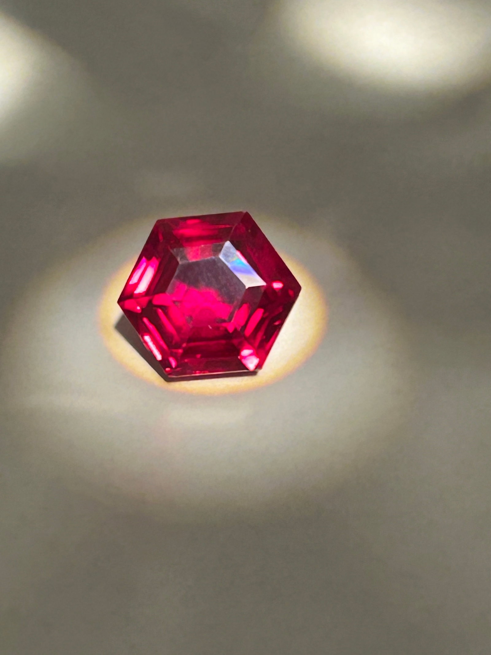 9.00 Carat ---- Red Ruby---- Hexagon Cut ---- GGI Certified: A geometric gemstone, sourced from Mozambique, characterized by its deep red color, sharp six-sided, faceted shape, and "eye-clean" to translucent clarity. Typically utilized for high-end, modern arch