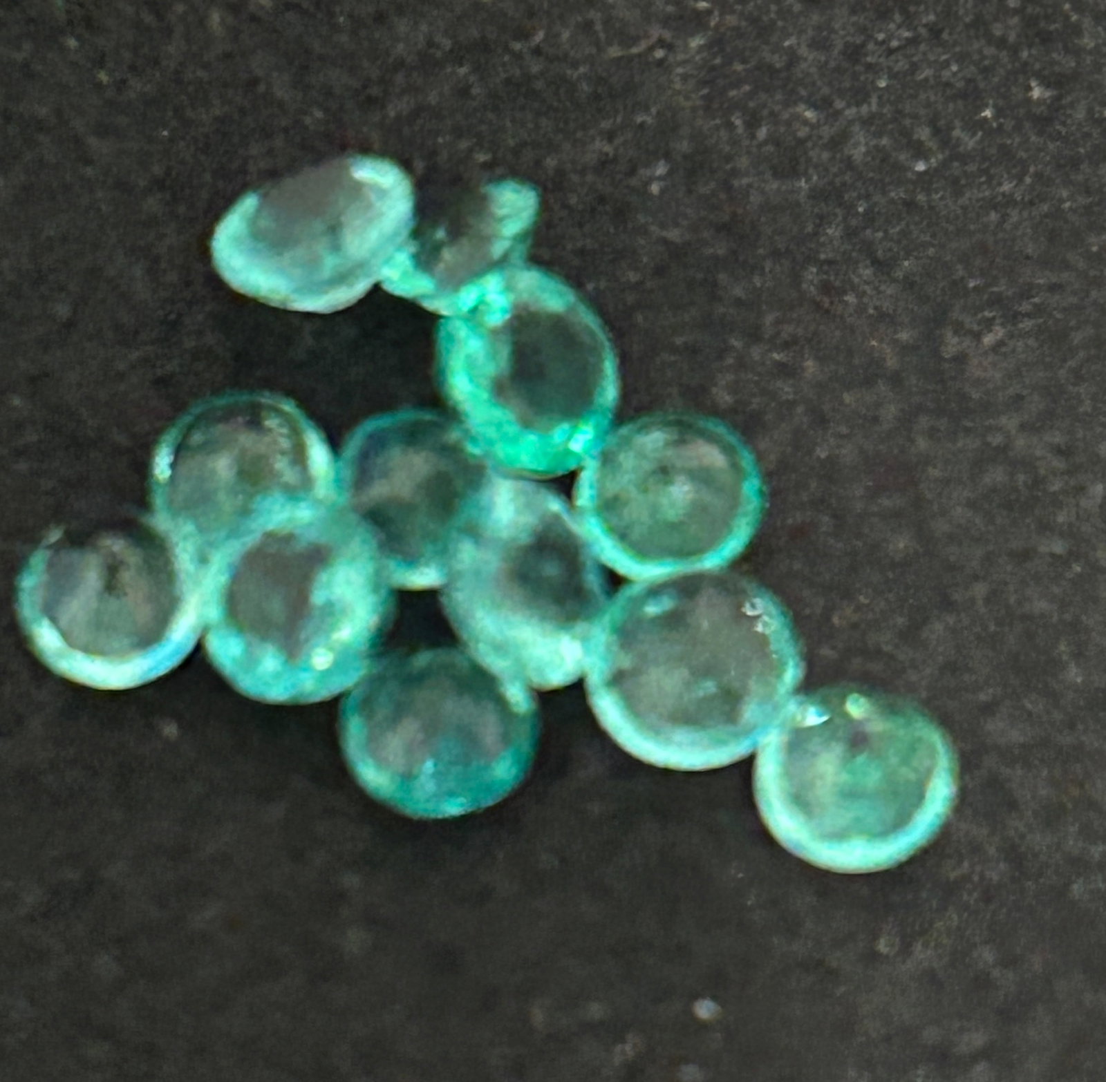 2 Carat --- Colombian Emeralds --- Round Cut --- 12 pcs: A 2-carat total carat weight lot of 12 natural Colombian emeralds, cut in a round shape, consists of smaller, calibrated stones used for accent, halo, or eternity jewelry.