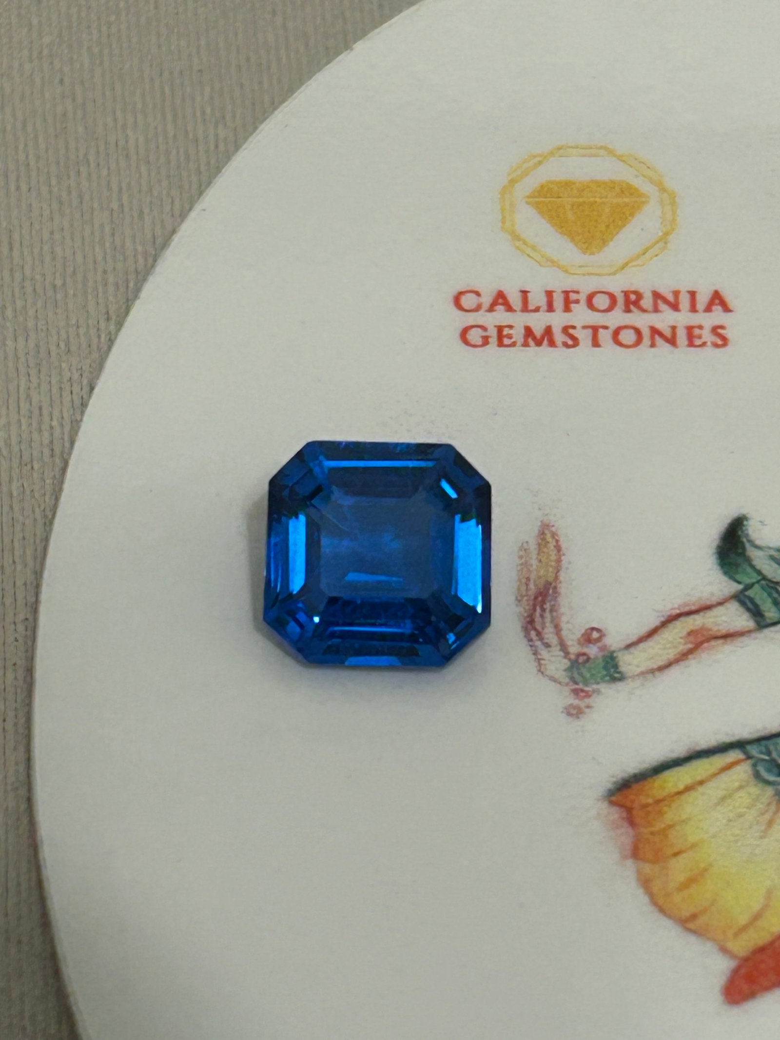 4.20 Carat Swiss Blue Topaz Asscher Cut: a vibrant, electric blue color paired with geometric step facets that create a striking "hall-of-mirrors" optical effect. Step cuts emphasize clarity and linear reflections rather than fiery sparkle.