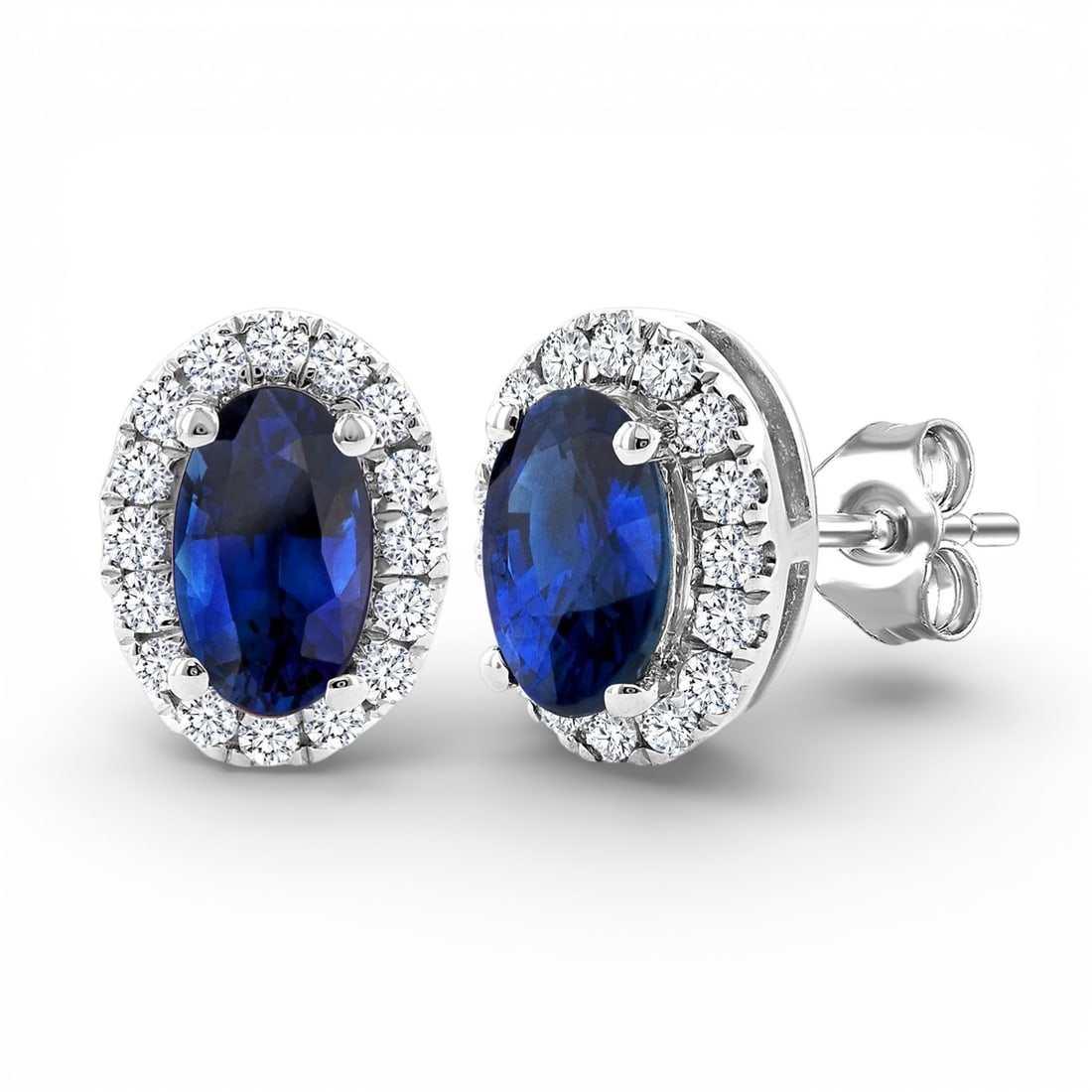 5x3mm Blue Sapphire and 0.14 ctw Diamond 10K White Gold Stud Earrings: A testament to superior craftsmanship, this elegant Halo pair of earrings featuring Blue Sapphire, White Diamond is unparalleled. A detailed Halo gallery secures the stones, rendered in 0.7 grams of l