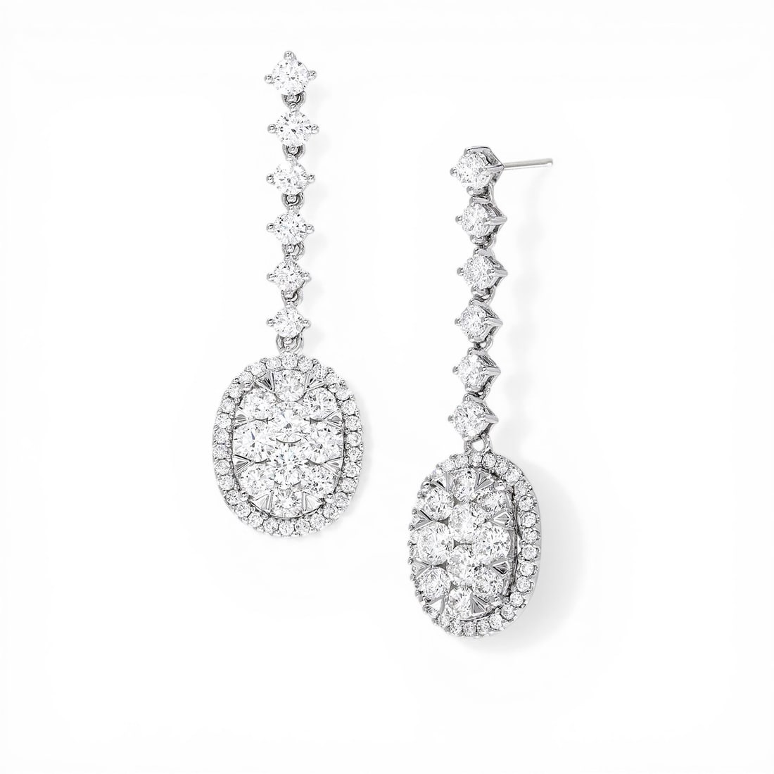 3.96 ctw Diamond Fiori Oval Drop Cluster 18K White Gold Earrings: A testament to superior craftsmanship, this breathtaking Fiori Oval Drop Cluster pair of earrings featuring Natural Diamonds is unparalleled. A detailed Halo gallery secures the stones, rendered in 8.