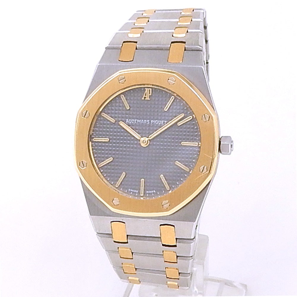 Audemars Piguet Royal Oak 56303SA 18k Gold & Steel Grey Dial: The Audemars Piguet Royal Oak, reference 56303SA.OO.0789SA.01, represents a masterclass in two-tone design. Featuring a classic 33mm case crafted from 18k yellow gold and stainless steel, this timepie