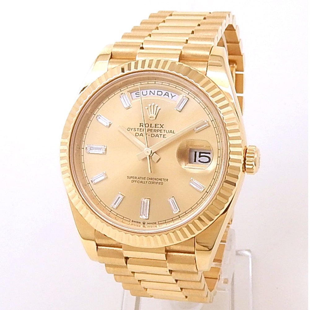 Rolex Day-Date 40 228238 18k Yellow Gold Champagne Baguette Diamond Dial: The Rolex Day-Date 40 Ref. 228238 represents the pinnacle of prestige and horological excellence. Cast in radiant 18k yellow gold, this timepiece features a stunning champagne dial elevated by exquisi