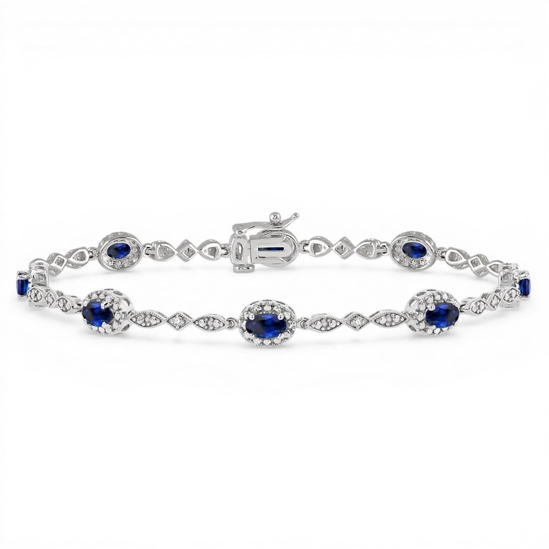 5x3mm Oval Blue Sapphire and 0.05 ctw Diamond 10K White Gold Bracelet: Rare and radiant, this exquisite Halo bracelet featuring Blue Sapphire, White Diamond offers a touch of the extraordinary. A detailed Prong gallery secures the stones, rendered in 5.1 grams of lustrou