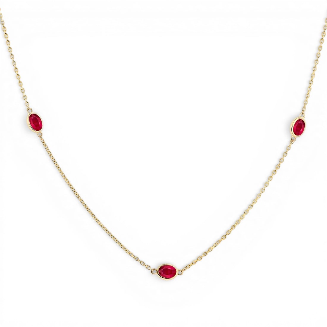 4x3mm Oval Ruby Bezel Station 14k Yellow Gold Necklace: A vision of luxury, this elegant Station necklace featuring Ruby defines sophistication. Securely held in a classic Bezel design, the necklace is forged from 2.45 grams of high-polish 14K Yellow Gold.