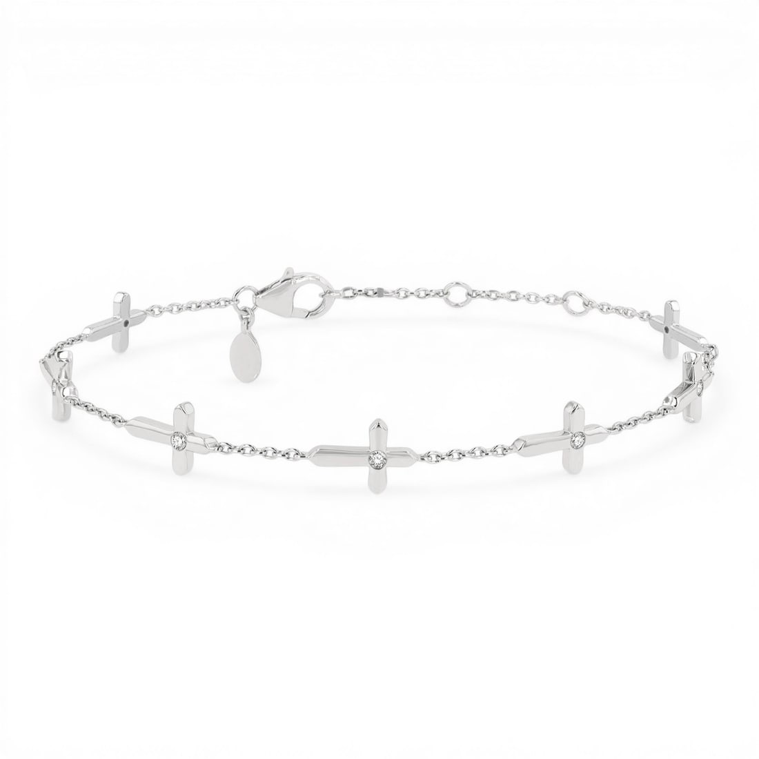 0.15 ctw Diamond Cross Charm Station 10K White Gold Bracelet: A vision of luxury, this elegant Cross Charm bracelet featuring Natural Diamonds defines sophistication. Expertly mounted in a Station setting, the bracelet is crafted in 2.85 grams of solid 10K White