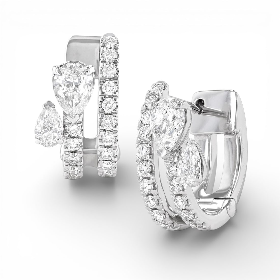 1.16 ctw Paradox Pear Diamond 18K White Gold Hoop Earrings: Captured in a moment of brilliance, this stunning Paradox Pear 2-Row pair of earrings featuring Natural Diamonds speaks to the connoisseur. The gemstones are nestled within a Hoop framework, supported