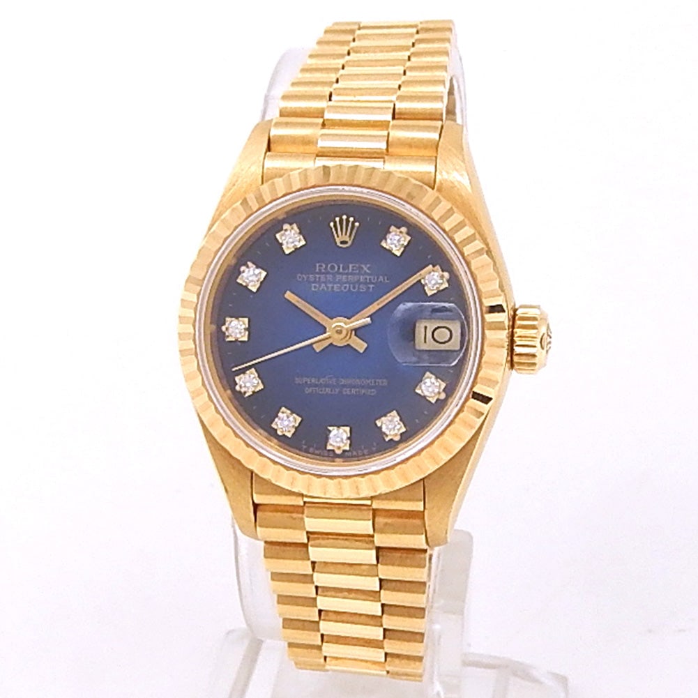Rolex Datejust President 69178 18k Yellow Gold Blue Vignette Diamond Dial: The Rolex Datejust President, Reference 69178, is an extraordinary expression of prestige and femininity. Masterfully crafted in 18K yellow gold, this classic 26mm timepiece showcases a rare and magni