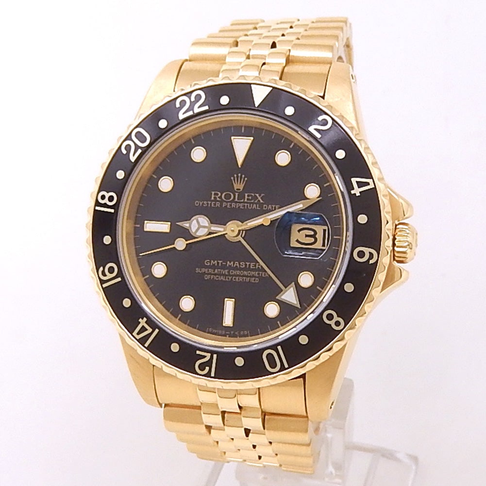 Rolex GMT-Master 16758 18k Yellow Gold Black Dial: The Rolex GMT-Master, Reference 16758, is an exceptional statement of luxury and utility. Crafted in stunning 18k yellow gold, this legendary pilot's watch features a classic black dial that offer