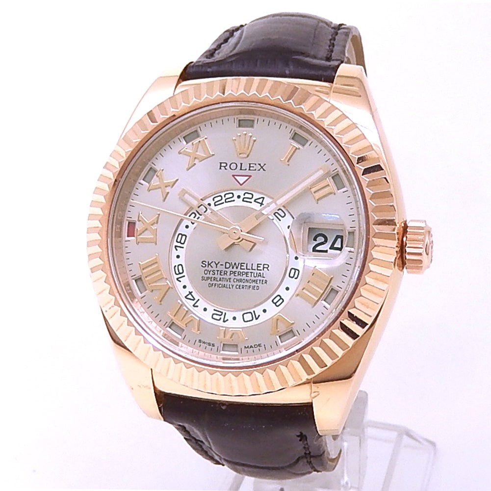 Rolex Sky-Dweller 326135 18k Rose Gold Sundust Dial: The Rolex Sky-Dweller, Reference 326135, represents the pinnacle of travel elegance and complication. Beautifully crafted in 18k Rose Gold, this distinguished timepiece features a radiant Sundust dial