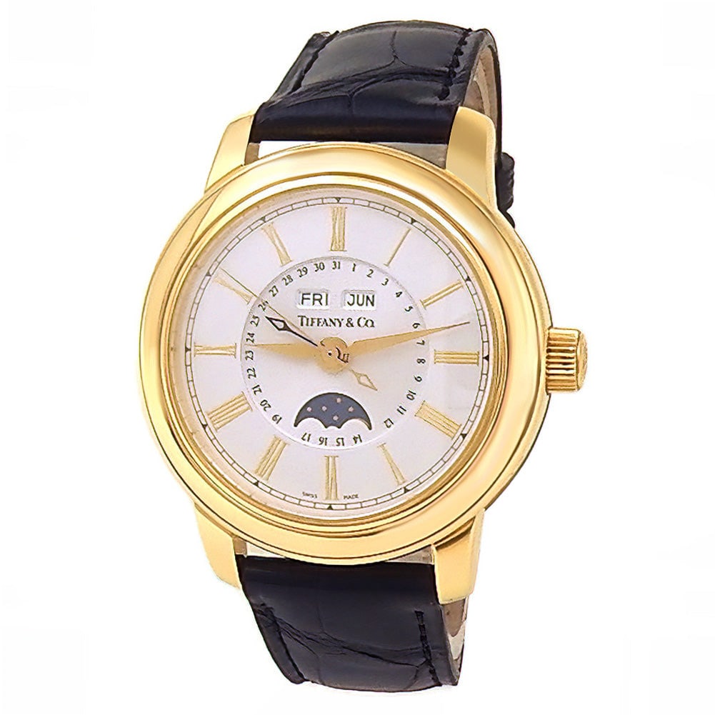 Tiffany & Co Triple Calendar Moon Phase 18k Yellow Gold Silver Dial: The Tiffany & Co. Triple Calendar Moon Phase is an exquisite fusion of classic American luxury and traditional Swiss horology. Cased in radiant 18k yellow gold, this dress watch showcases a refine