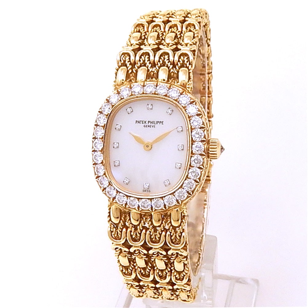 Patek Philippe Golden Ellipse 4931/2J 18k Yellow Gold Diamond Mother of Pearl Dial: The Patek Philippe Golden Ellipse, Reference 4931/2J, is a paragon of refined elegance. Crafted entirely in 18k yellow gold, this ladies' timepiece features a lustrous mother-of-pearl dial adorned
