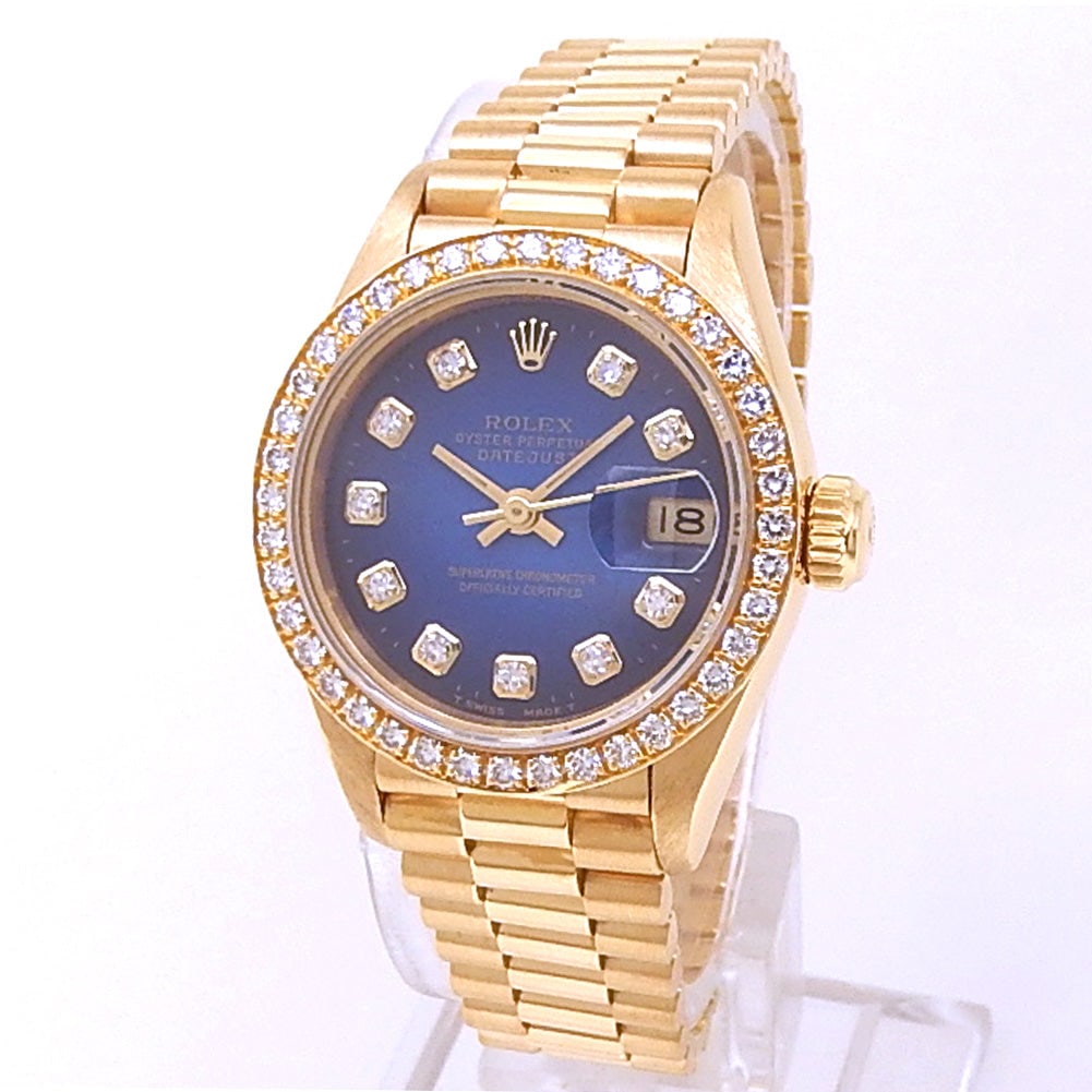 Rolex Lady Datejust 69138 18k Yellow Gold Diamond Blue Vignette Dial Ladies Watch: The Rolex Lady Datejust, Reference 69138, is a stunning example of timeless elegance. Crafted in 18k Yellow Gold, this ladies' timepiece features a captivating Blue Vignette dial, enhanced by