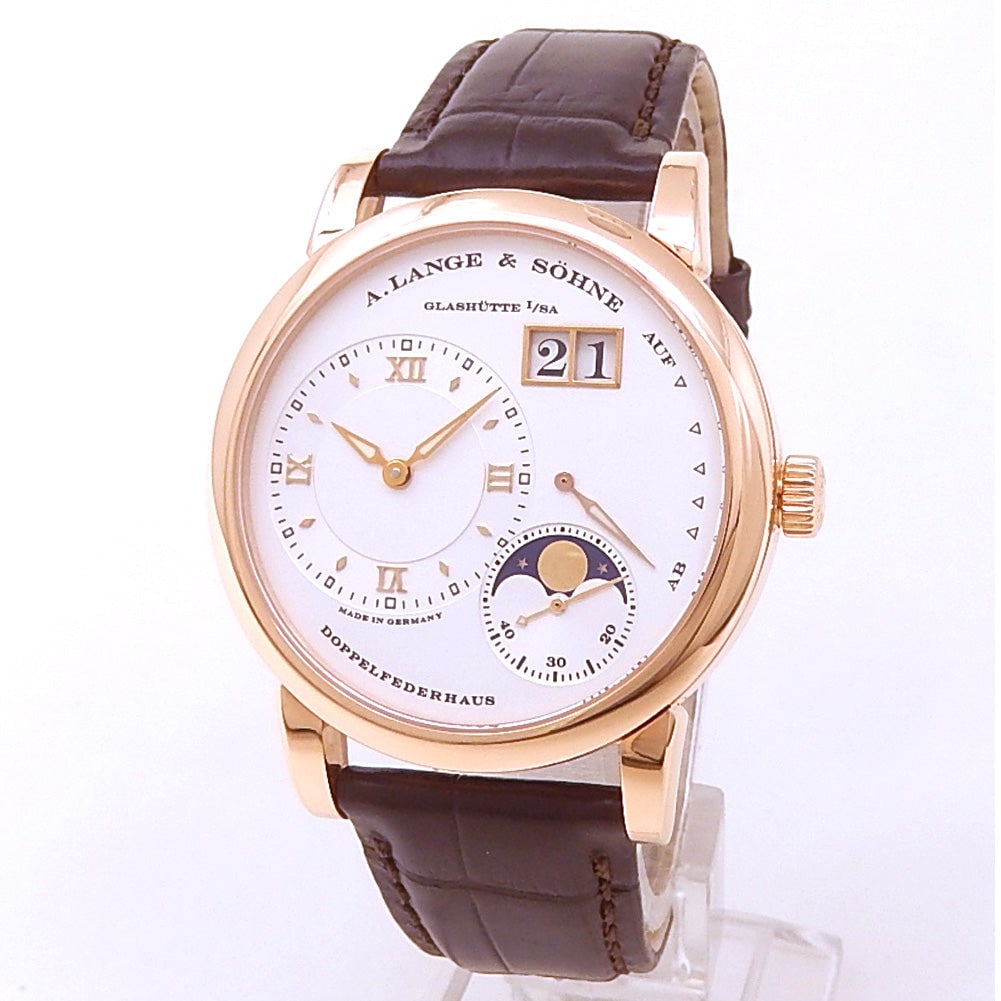 A. Lange & Sohne Lange 1 Moon Phase 109.032 18K Rose Gold Silver Dial: The A. Lange & Sohne Lange 1 Moon Phase, Reference 109.032, is a masterpiece of German watchmaking. Crafted in 18k rose gold, the 38.5mm case frames a stunning silver dial, featuring the iconic ou