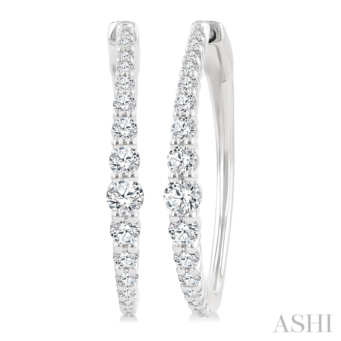 1.0 ctw Graduated Diamond Riviera 14K White Gold Hoop Earrings: An exquisite masterpiece of haute joaillerie, this breathtaking Riviera pair of earrings featuring White Diamond is a true treasure. Showcasing the gems in a Riviera arrangement, the earrings consists