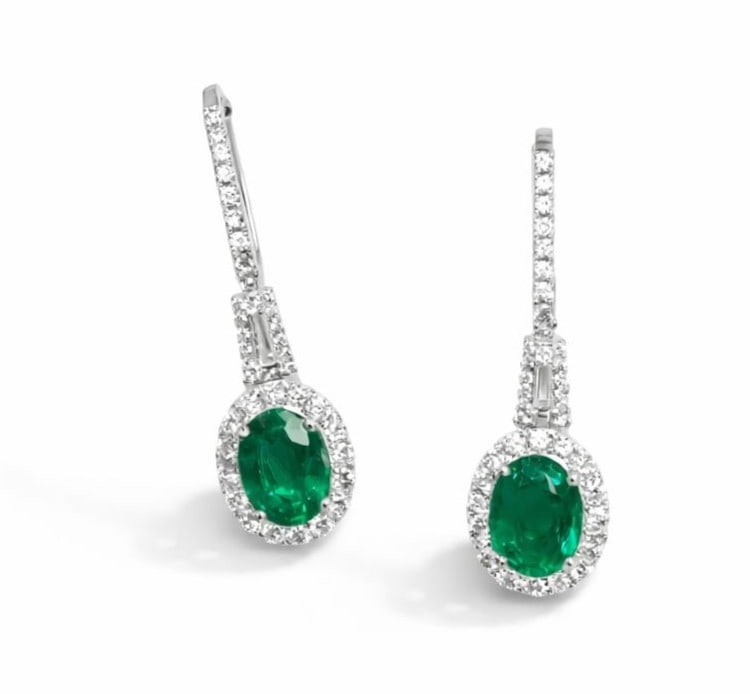 3.48ct Oval Emerald and 1.30ctw Diamond 18K White Gold Dangling Earrings: Epitomizing grandeur, this breathtaking Halo Dangling pair of earrings featuring Emerald, White Diamond stands as a beacon of refined taste. Showcasing the gems in a Halo arrangement, the earrings con
