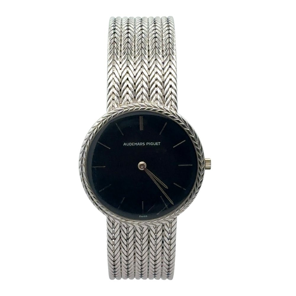 Audemars Piguet Cobra 18K White Gold Black Dial 34mm: The Audemars Piguet Cobra, a captivating design from the 1970s, is a masterpiece of sculptural elegance. Crafted in a luminous 18K white gold case, this timepiece features a dramatic black index dial