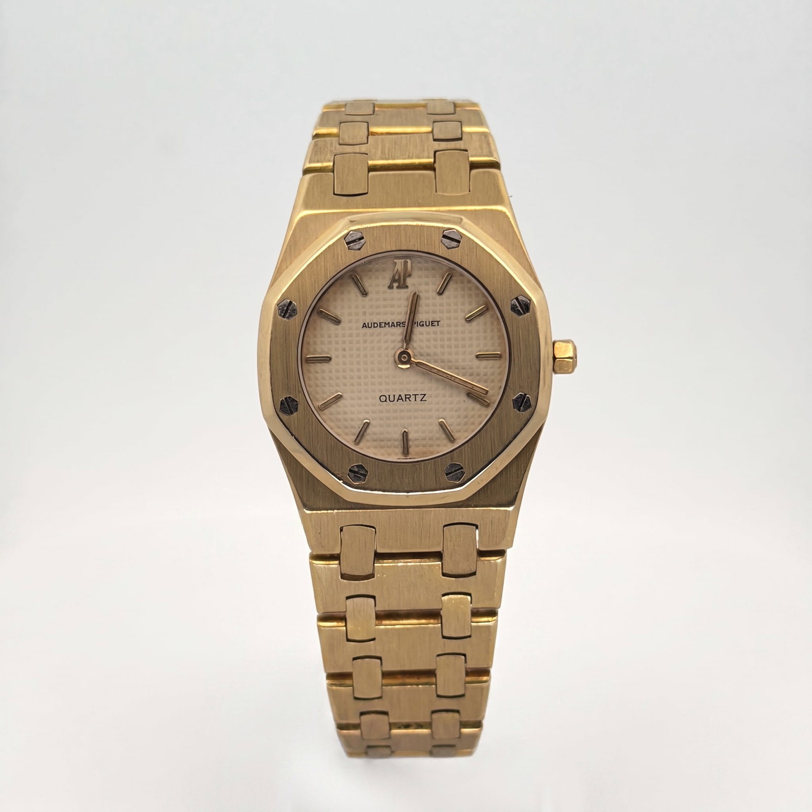 Audemars Piguet Royal Oak 6007BA Yellow Gold Champagne Dial: The Audemars Piguet Royal Oak Lady, Reference 6007BA, is an exquisite expression of horological elegance. Encased in radiant yellow gold, its 26mm case is crowned by the iconic octagonal bezel, secure