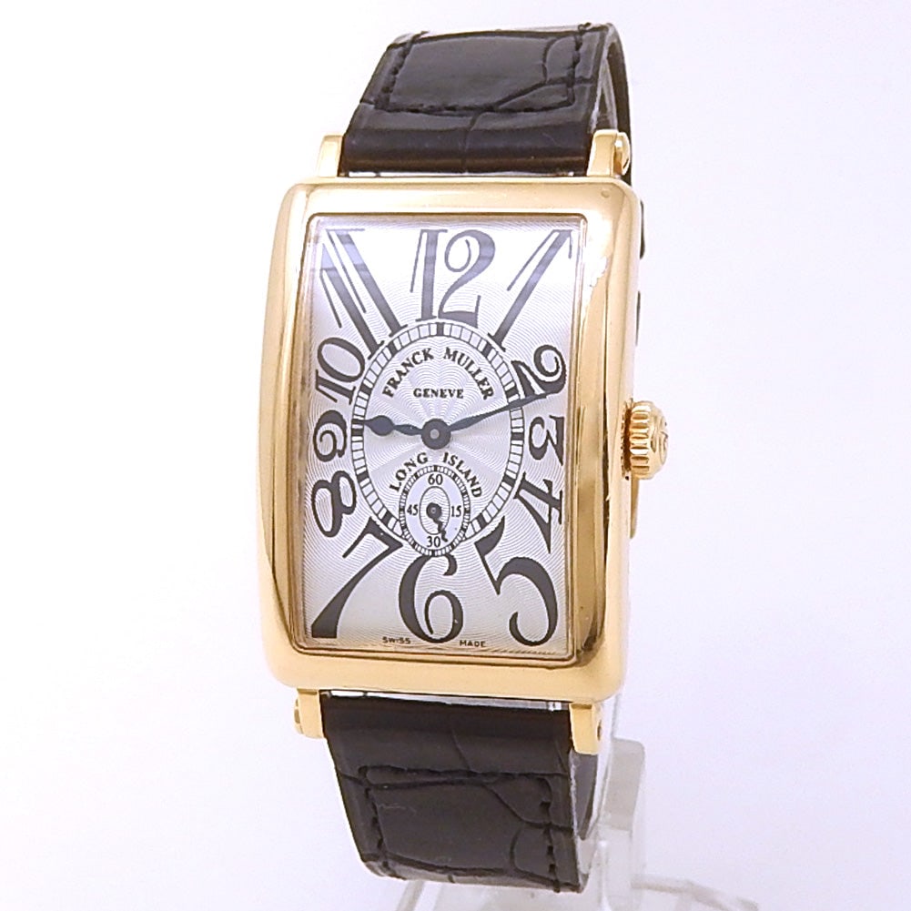 Franck Muller Long Island 950 S6 18k Yellow Gold Silver Dial: The Franck Muller Long Island, Reference 950 S6, is a masterful expression of horological elegance. Crafted from luxurious 18k yellow gold, its iconic curved tonneau case houses a stunning silver dial