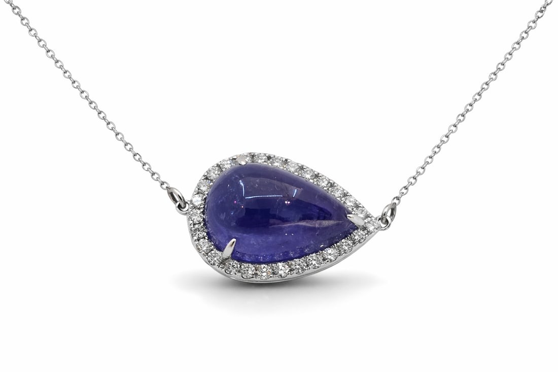 7.27ct Tanzanite and 0.30ctw Diamond 14K White Gold Pendant: Timeless and sophisticated, this elegant Halo pendant featuring Tanzanite, White Diamond radiates enduring beauty. Expertly mounted in a Halo setting, the pendant is crafted in 1.87 grams of solid 14K