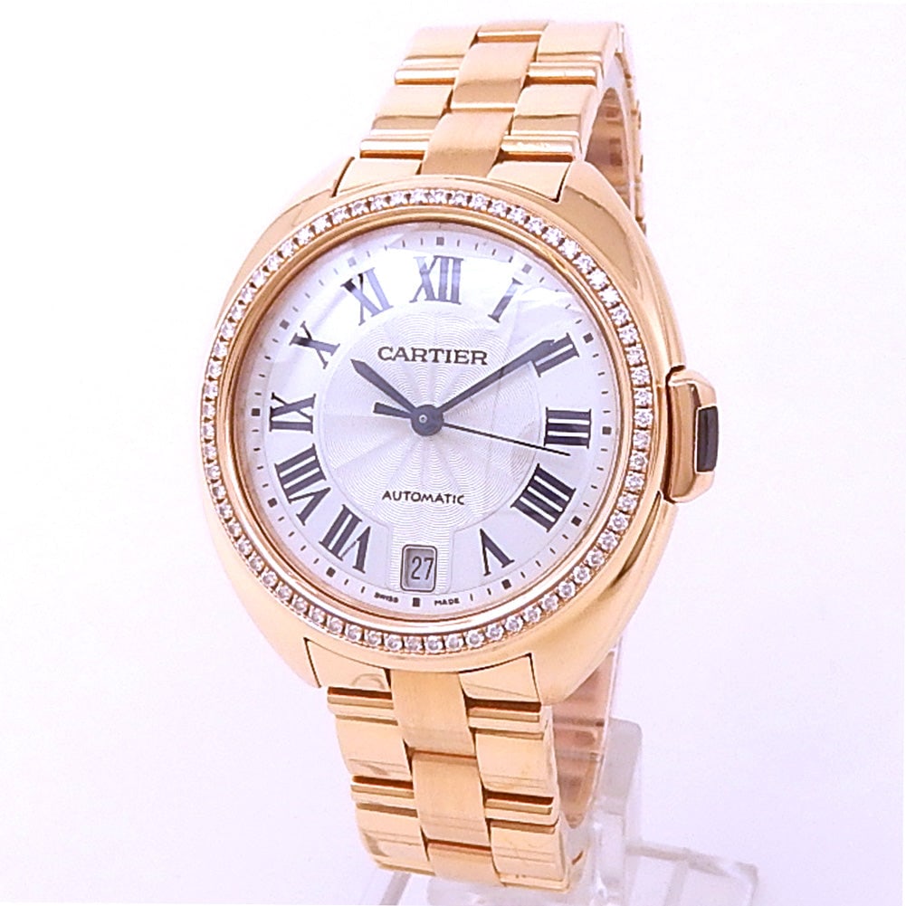 Cartier Cle de Cartier WJCL0006 18k Rose Gold Diamond Bezel Silver Dial: The Cartier Cle de Cartier, Reference WJCL0006, exemplifies the Maison's mastery of elegant watchmaking. Crafted in sumptuous 18k rose gold, this ladies' timepiece presents a refined silver dial d