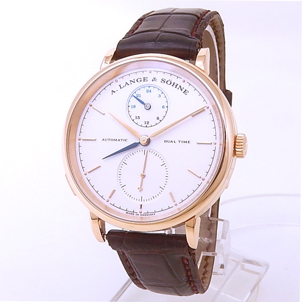 A.Lange & Sohne Saxonia Dual Time 385.032 18k Rose Gold Silver Dial: The A.Lange & Sohne Saxonia Dual Time, Reference 385.032, is a masterpiece of understated elegance. Crafted in 18k rose gold, the smooth bezel frames a stunning silver dial that features a dual ti