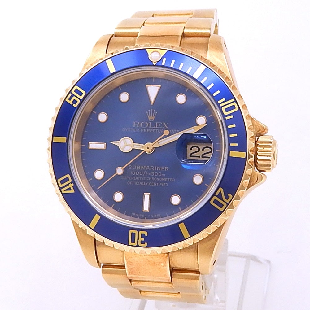 Rolex Submariner Date 16618 18k Yellow Gold Blue Dial: The Rolex Submariner Date, Reference 16618, is an icon of diving and elegance. Crafted from 18k Yellow Gold, its luxurious case frames a stunning Blue dial with a date window at 3 o'clock, perfect