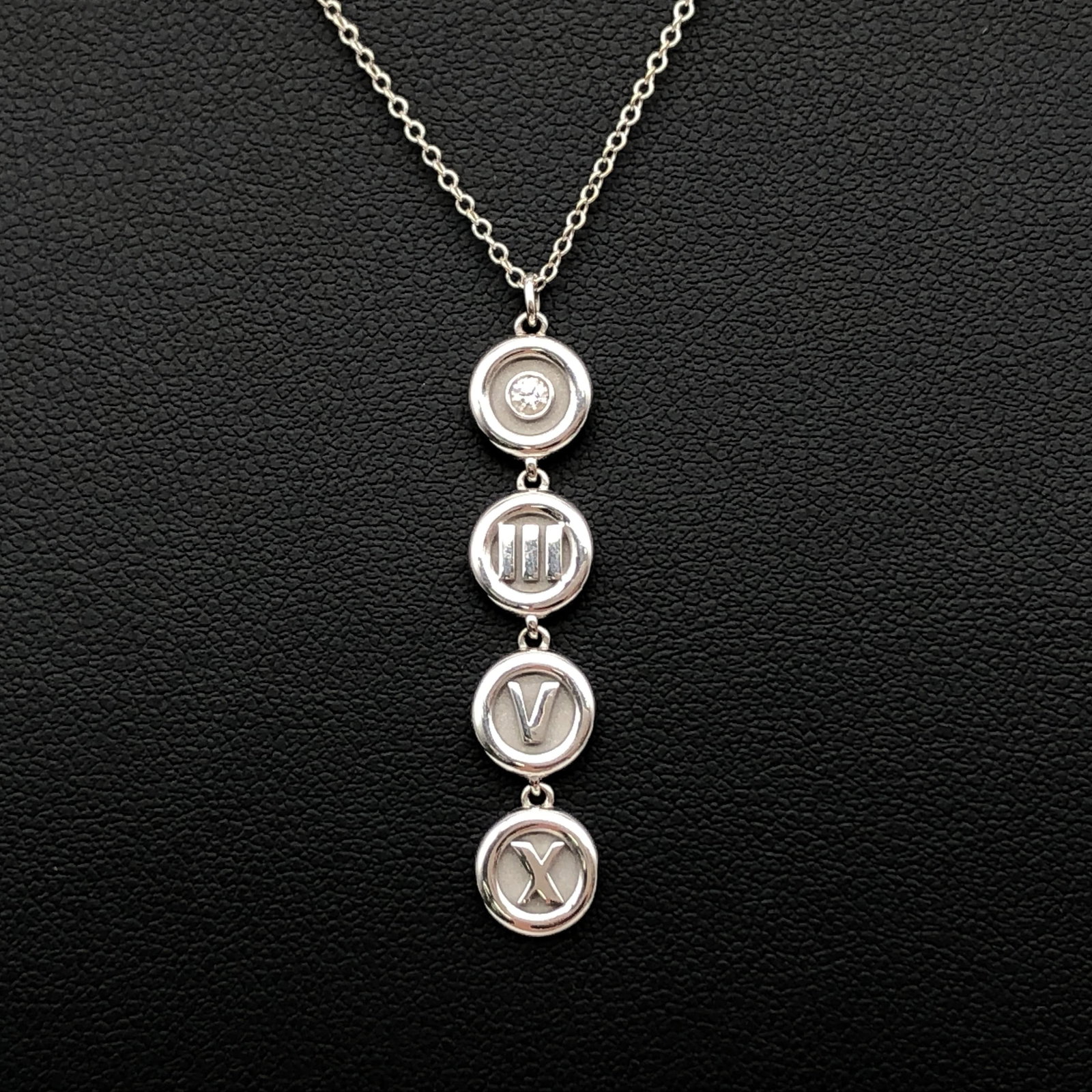 Tiffany & Co. Atlas Round 18k White Gold Diamond Necklace: This Tiffany & Co. Atlas Round Diamond Necklace features the signature motif of the Atlas collection, crafted in 18k white gold and centered with a single diamond. The necklace weighs 4.6 grams and me