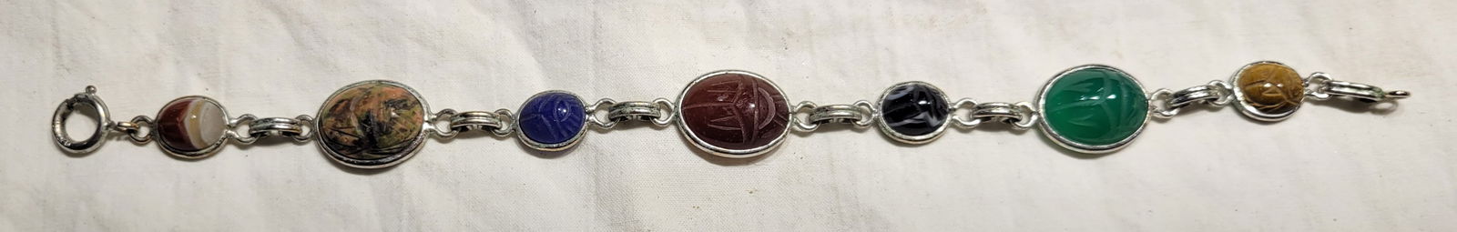 Vintage Egyptian Revival style bracelet: 12K gold filled features multiple colorful carved gemstones including onyx, lapis lazuli, tiger's eye, and carnelian - symbolizes protection and good luck