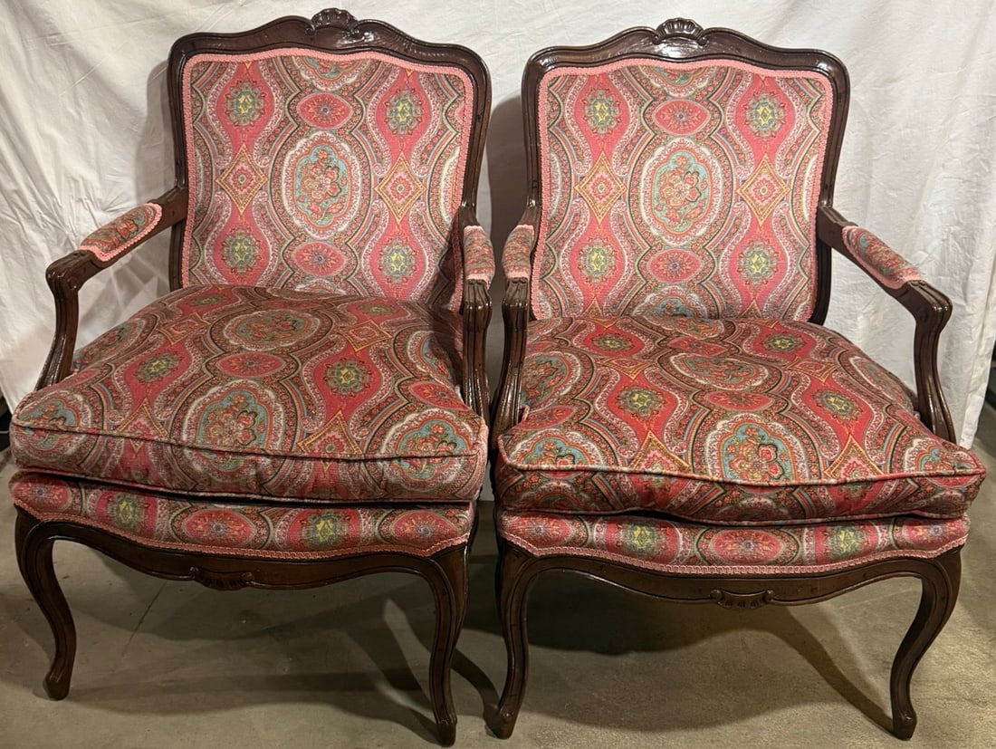 Pair of Louis XV Style Armchairs: Set of two Louis XV style armchairs with carved wood frames and upholstered cushions. Classic design with patterned fabric. Approx. 38.5” tall x 24” wide.