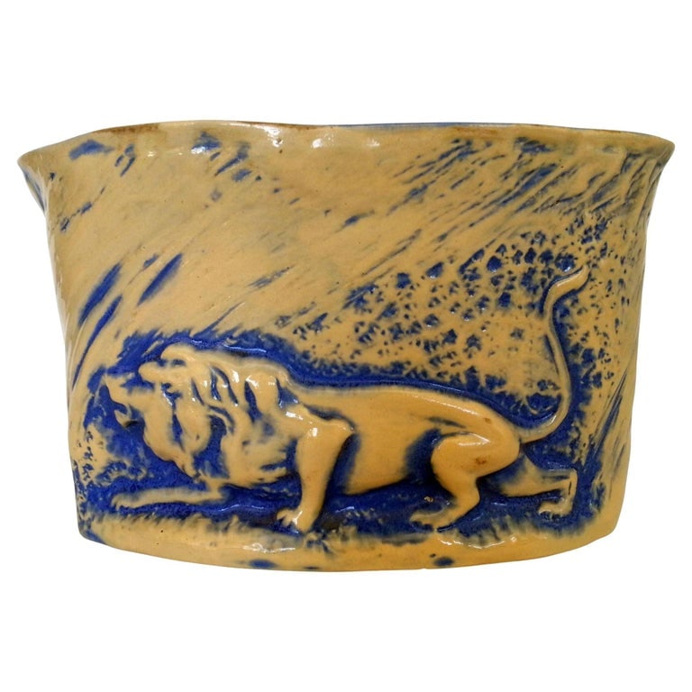 Mid-Century California Pottery Brown & Blue Stalking Lion Vase: Mid-century California Pottery ceramic vase featuring a sculpted stalking lion motif. The piece showcases a warm sand-colored glaze accented by deep cobalt blue detailing, creating a dramatic contrast