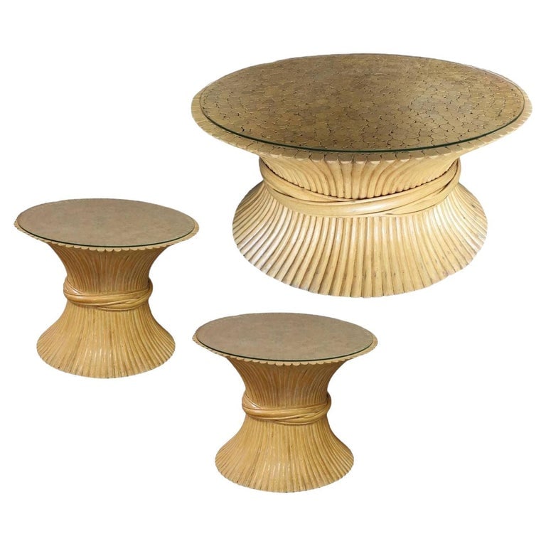 Restored Mcguire Corseted Hour Glass Rattan Coffee Table and Side Tables Set: This beautifully restored rattan blends vintage charm with modern comfort. A pair of rattan side tables and coffee table by McGuire feature sculptural organic modern hourglass design and glass tops. T