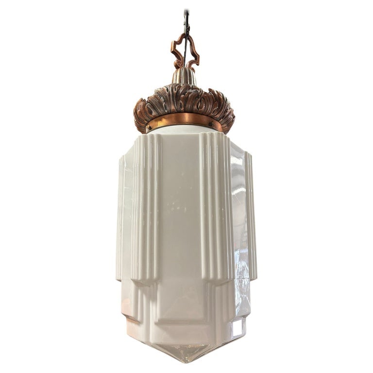 Art Deco Copper Acanthus Leaf Pendant Light w/ Skyscraper Milk Glass Shade: 1930s Art Deco pendant light featuring a stepped and line-textured "Skyscraper" milk glass shade and ornate cast brass fitter with a warm copper finish. The crown showcases acanthus leaf detailing, ad
