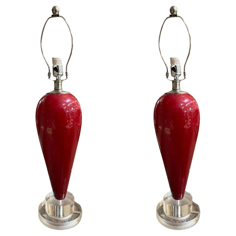 90s Pair of Red Ceramic Tear Drop Shaped Table Lamp w/ Acrylic Base: These 90s-style table lamps come in a bright red tear-drop shape made of ceramic. They sit on clear acrylic bases, giving them a modern look. These lamps add a pop of color and style to any room.