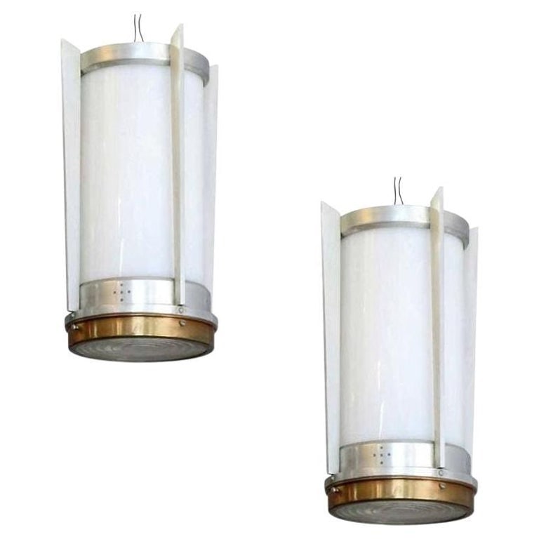 Mid-Century Aluminum Cylinder Hanging Lamp Pair, circa 1960: This pair of mid-century hanging lamp was manufactured during the Jet Age period of the Space Race and America's obsession with speedy flight and reaching to the stars.It shows all the hallmarks of it