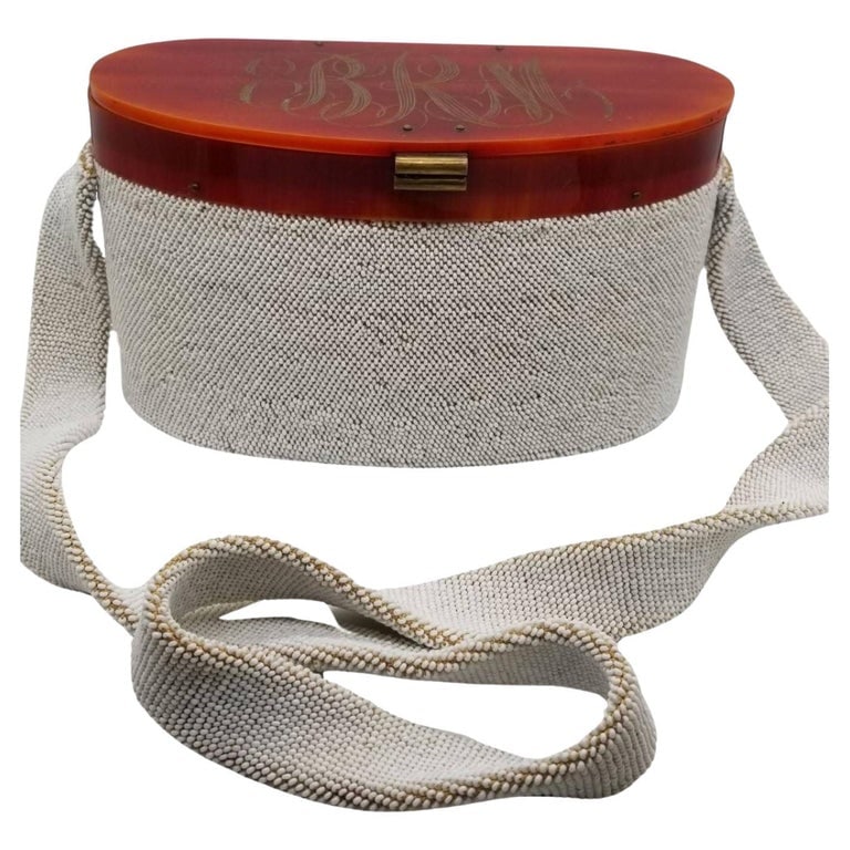 White Caviar Bead Box Purse w Tortoiseshell Celluloid Lid and Long Strap, 1950s: This charming 1950s purse is a true vintage gem. Crafted with meticulous attention to detail, it features a tortoiseshell celluloid lid and a stylish braid handle, adding a touch of sophistication to