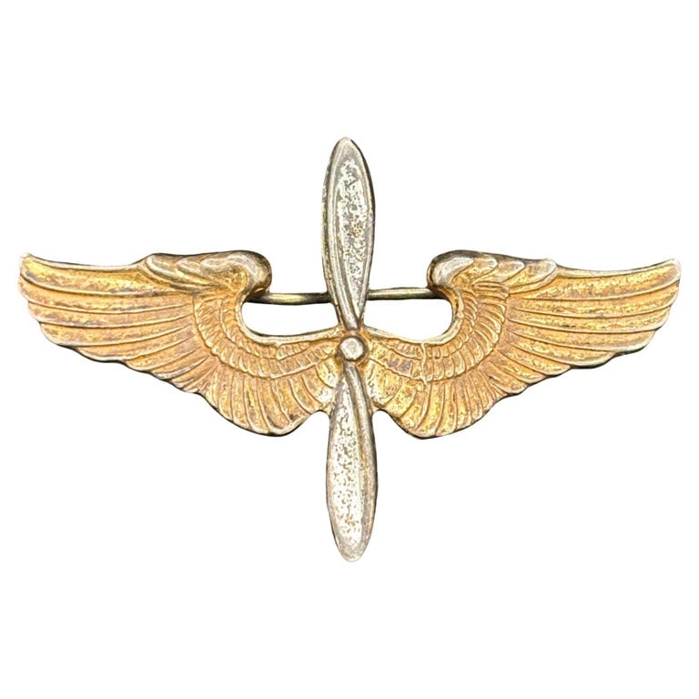 WWII US Army Air Corps Cadet Sterling Silver Badge Pin by Meyer: Original World War II U.S. Army Air Corps Aviation Cadet cap insignia, manufactured by Meyer of New York. Crafted in two parts, it features gold-plated wings and a silver-plated two-blade propeller, s