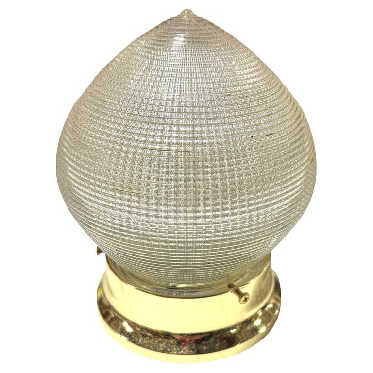 Mid-century Holophane Ceiling Light Teardrop Globe with Brass Fitter: Mid-century era Holophane ceiling light features a distinctive teardrop-shaped glass globe. Its prismatic design diffuses light beautifully. A warm, aged brass fitter secures the globe, adding
