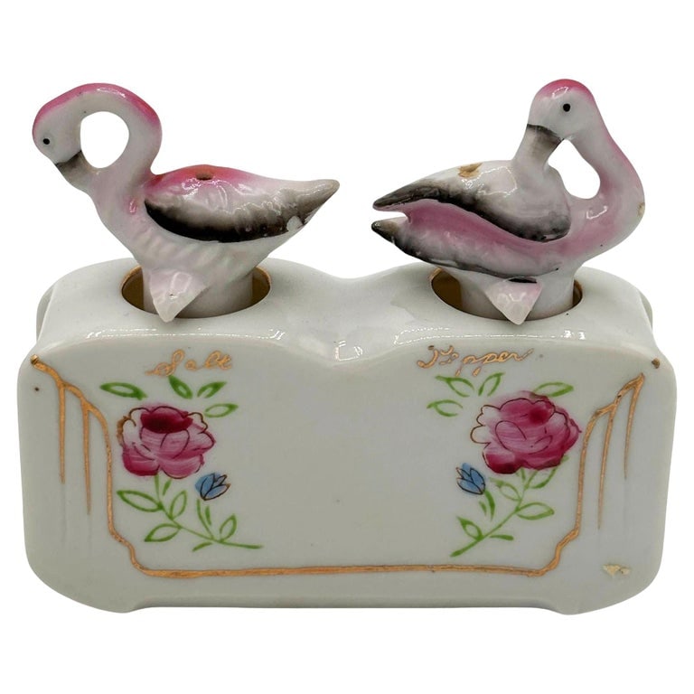Mid-century Flamingo Ceramic Tabletop Salt & Pepper Shaker Set w/ Base: Mid-century pink and green ceramic flamingo tabletop salt & pepper with a holding base by Express. The set features two beautifully detailed pink flamingos in white with a holding base that has a deco