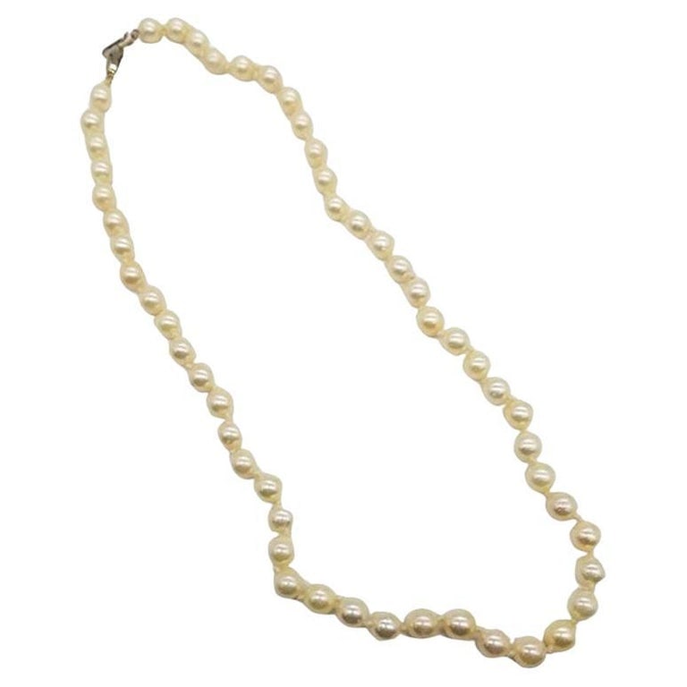 Mid-century South Sea Roud Pearl Choker Necklace on Silk Cord w/ Silver Clasp: An emblem of mid-century grace, this South Sea light golden tone sea water pearl choker necklace is a refined statement featuring delicate pearls, elegantly strung on fine silk cord. Accentuated by a