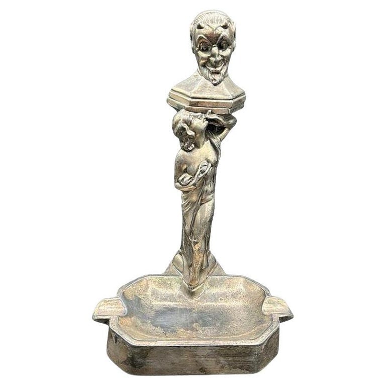 RARE Nude Smoking Women w/ Temptation Devil Figurative Ashtray w/ Lighter: This 1920s white metal table lighter and ashtray features a Devil/Satyr bust above a smoking nymph with her bare breasts exposed capturing the story of temptation in the garden of Eden, replacing an a
